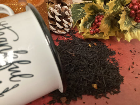 Black loose tea spilled among christmas decorations