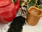 black spice tea spilled among pincones and candle