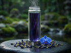tall glas vial with purple colored tea with a butterfly pea flower