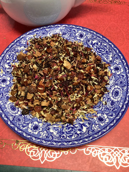 Lemon Raspberry Moringa Tea.  Loose leaf tea displayed on a blue and white plate in a red background